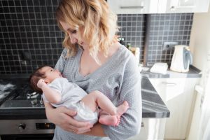 Young mother is holding her newborn baby